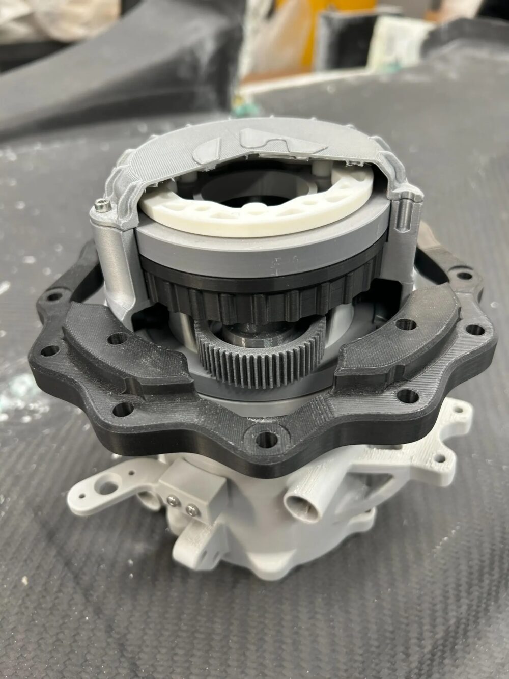 3D printed rapid prototype model of a complex motorsport wheel hub assembly with planetary gears used for CNC machining design verification.