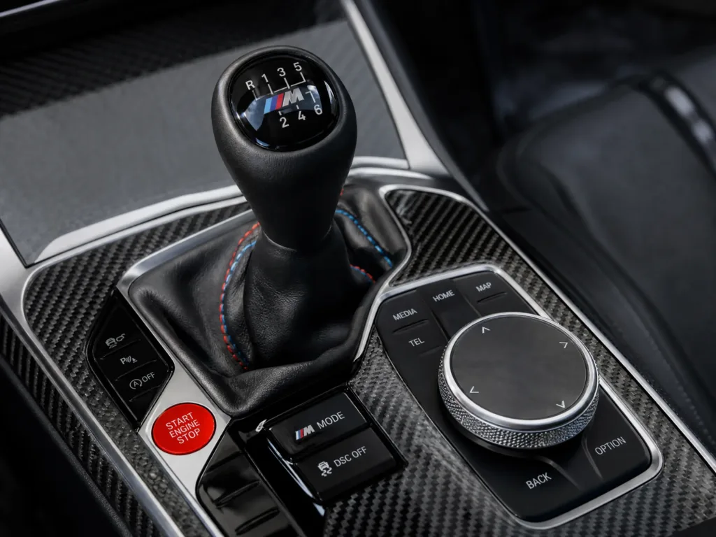 Manual gear shifter and carbon fiber console featuring advanced automotive parts overmolding.