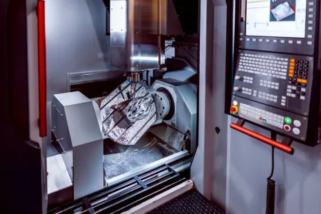 a 5-axis Milling machine at work, creating a component of a helmet throught CNC milling services